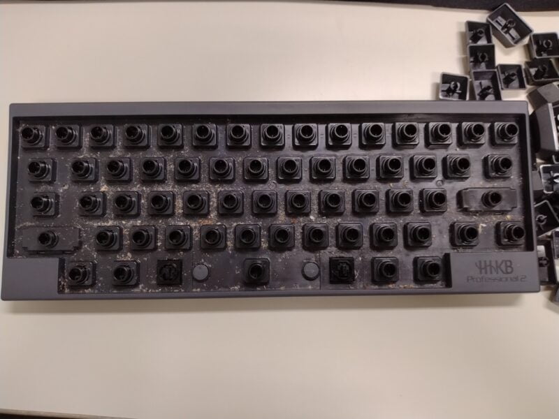 HHKBのキーボードのキートップを全て外した画像。隙間からゴミが大量にはいりこんでいたことがわかる